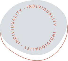 Pale gray circular badge with rust text around edge reading INDIVIDUALITY • INDIVIDUALITY • INDIVIDUALITY