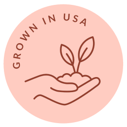 Circular peach badge with a hand holding a seedling and the words GROWN IN USA
